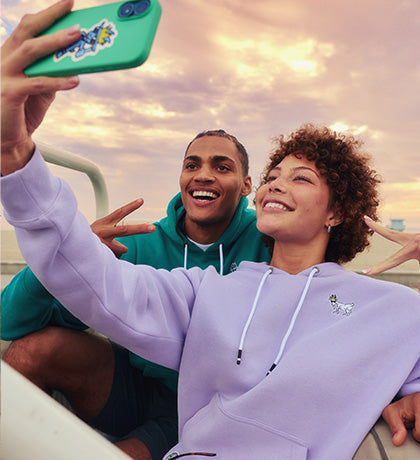 Four people posing in front of a vintage car