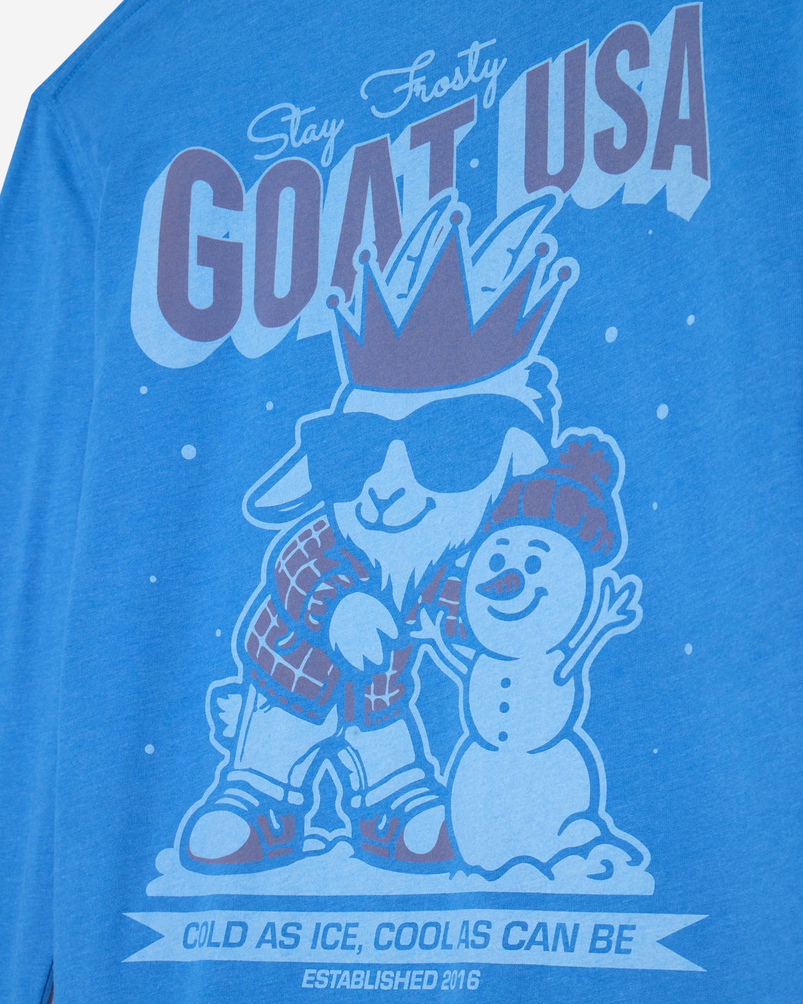 Blue t-shirt with a graphic of a goat and snowman, text 'Stay Frosty GOAT USA', and establishment year.