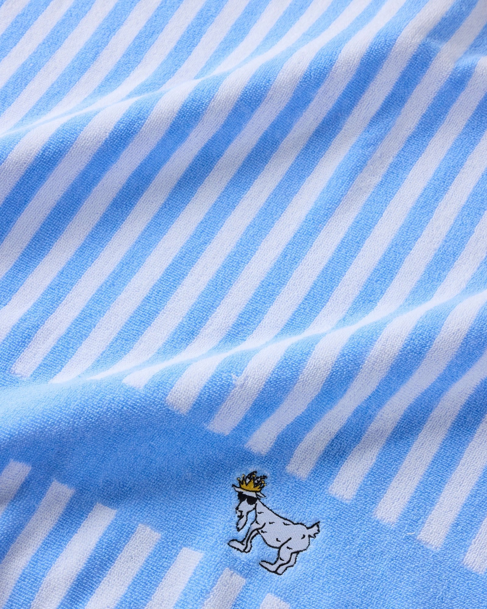 Close-up of blue and white striped fabric with a small black and white illustration.