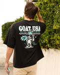 Person wearing a black 'GOAT USA' t-shirt with a graphic design on the back, standing outdoors.