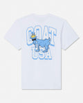 A white short-sleeve t-shirt with a graphic print on the front featuring a blue cartoon goat wearing sunglasses and a gold crown, set against large light blue and white block letters spelling 'GOAT USA'.
