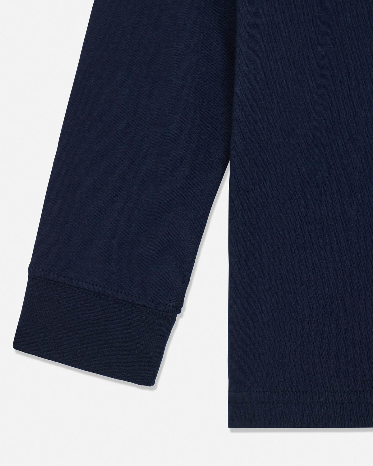 Close-up of a navy blue long-sleeve garment, showing the cuff of one sleeve and the hem of the other, on a light gray background.