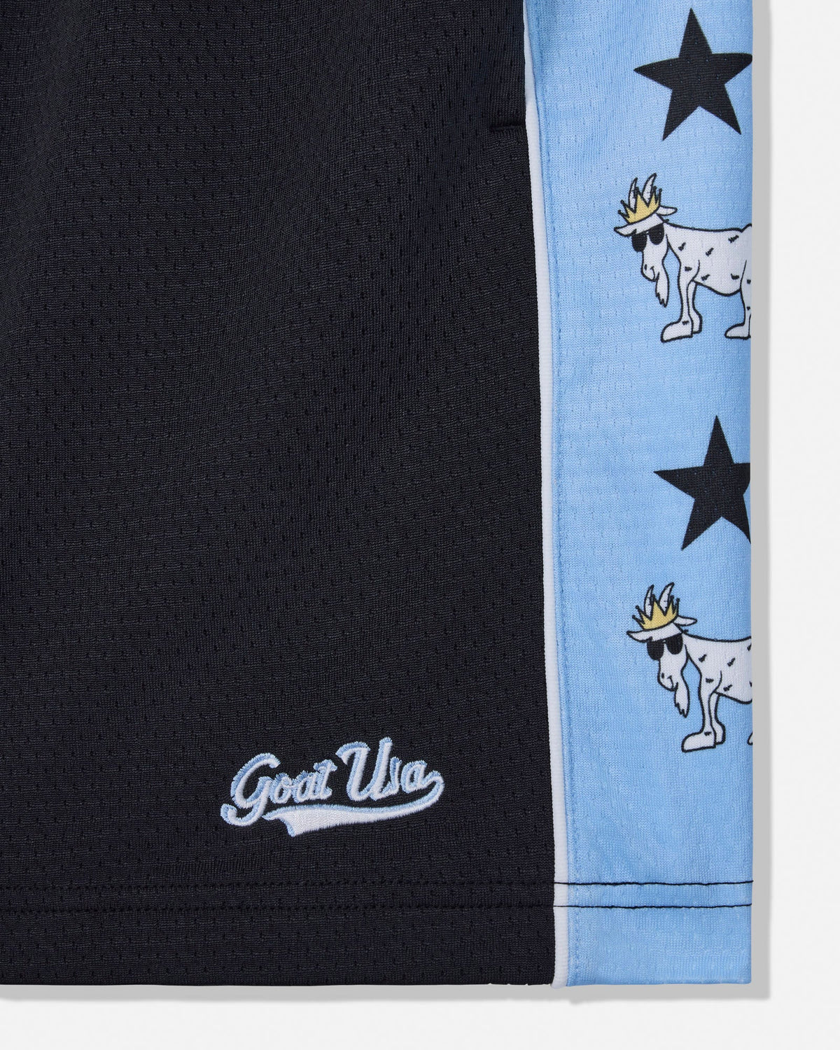 Close-up of black athletic shorts with a light blue side stripe featuring black stars and white goat illustrations, plus a white embroidered 'Goat USA' logo near the hem.