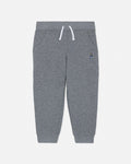 Gray sweatpants with a small embroidered design on a light gray background
