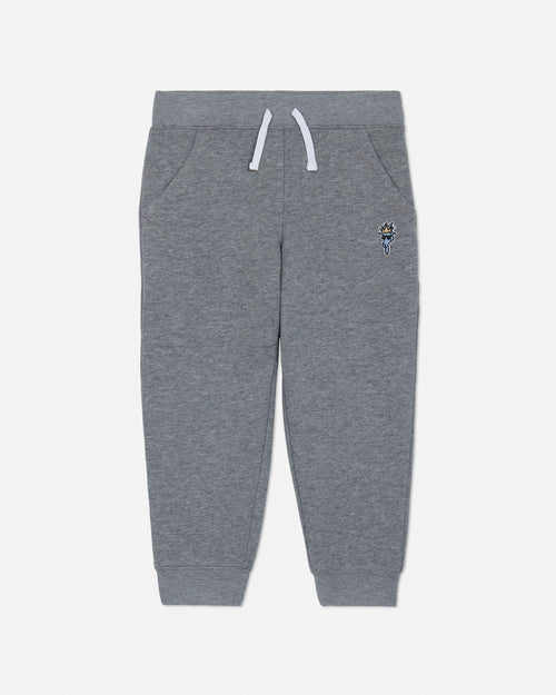 Gray sweatpants with a small embroidered design on a light gray background