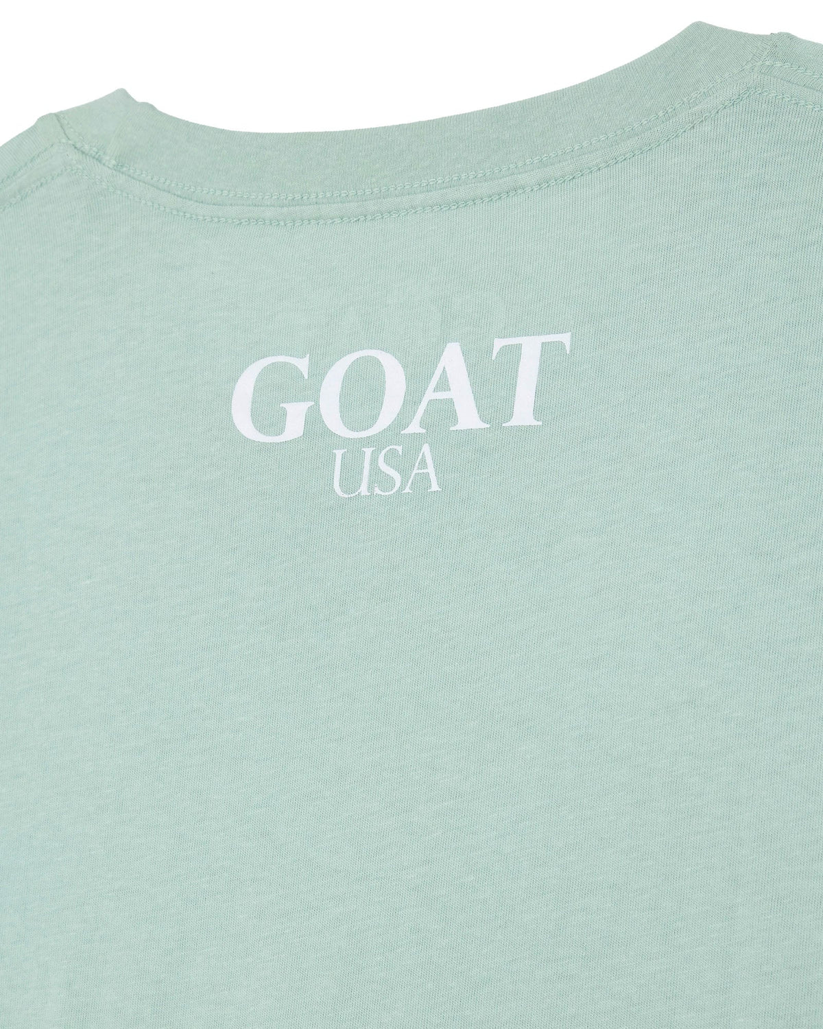 Close-up of a light mint green t-shirt with 'GOAT USA' printed in white on the back.