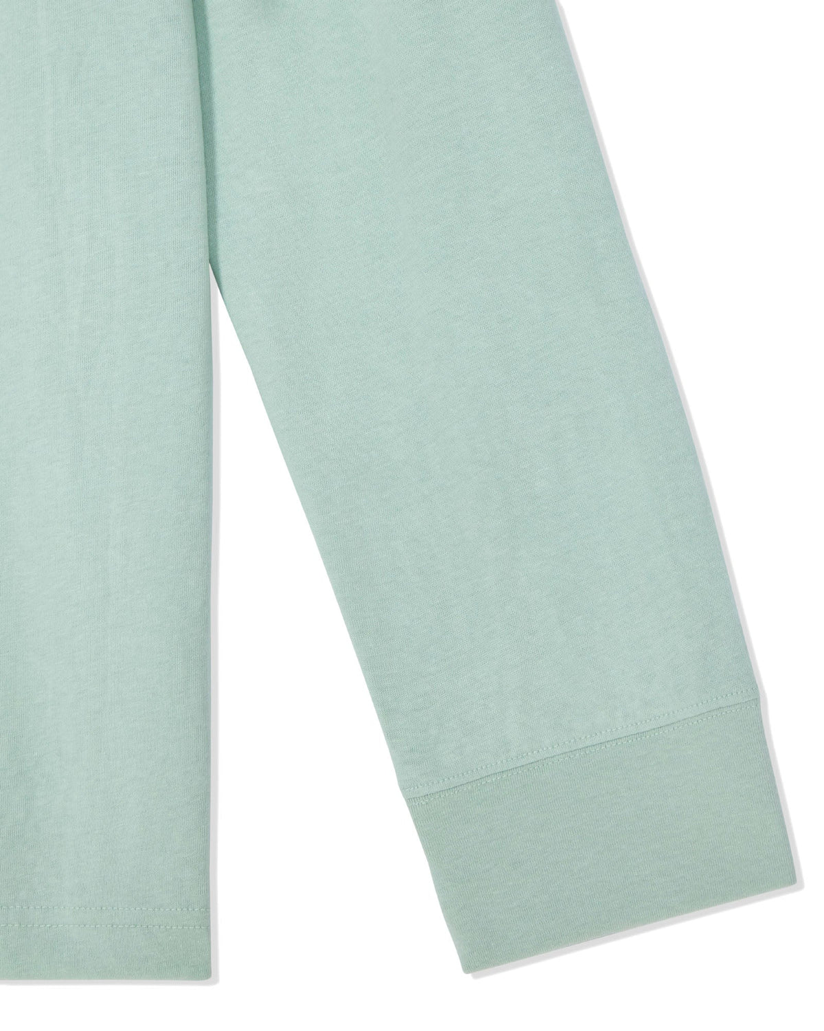 A close-up of a light mint green garment, showing the fabric texture and cuff detail on a plain white background.
