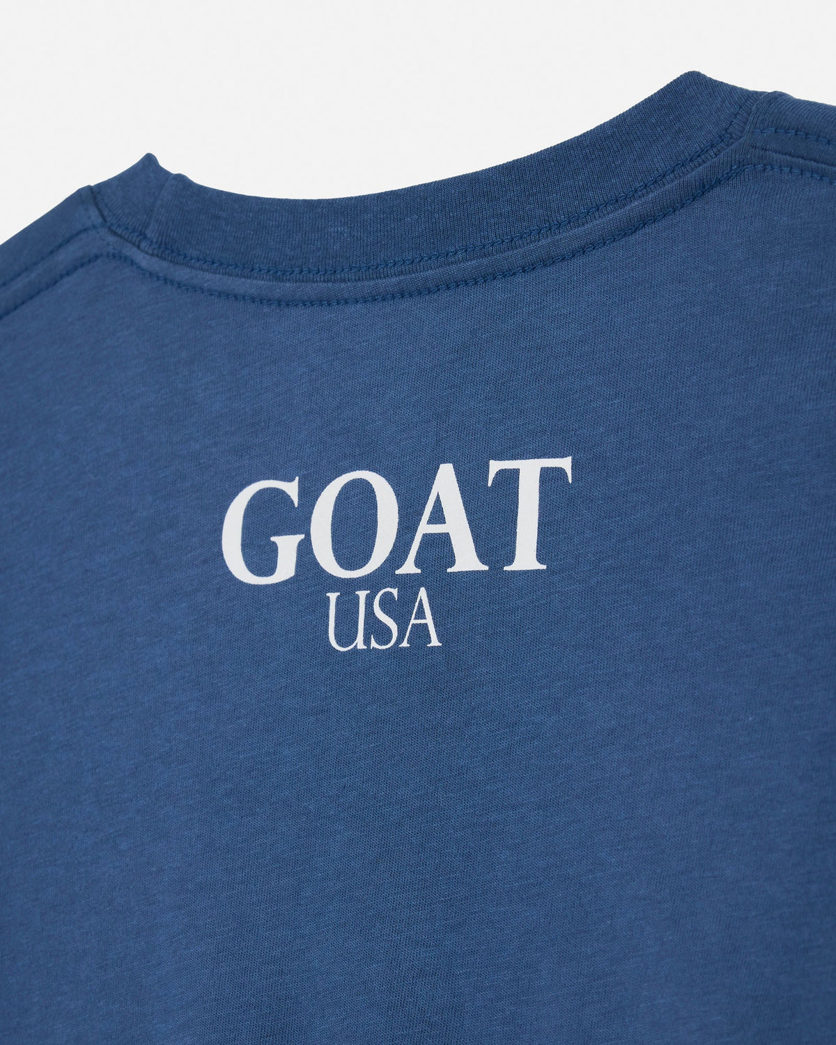 Close-up of a blue heather crewneck t-shirt with 'GOAT USA' printed in white text on the chest.