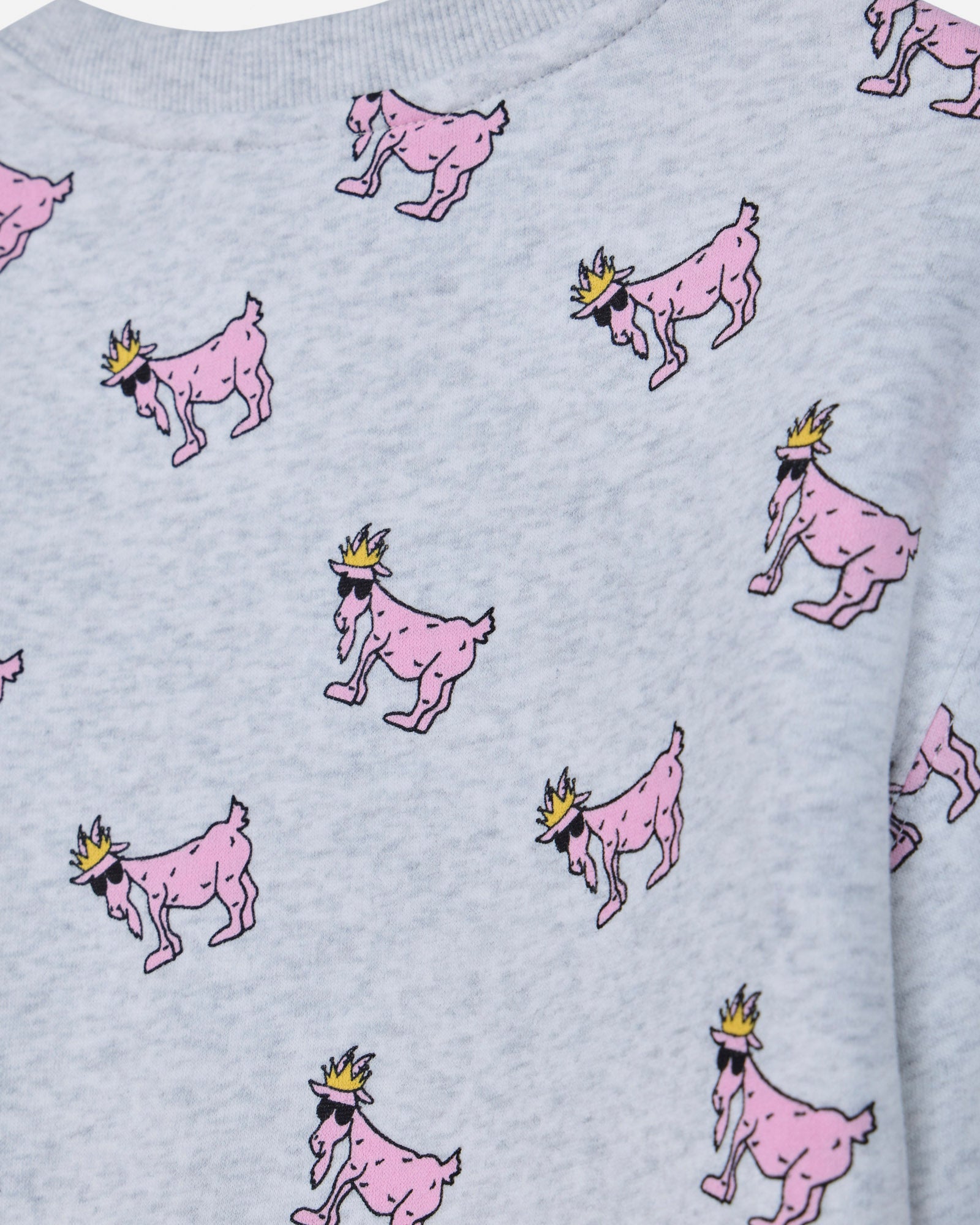Close-up of a light gray heather sweatshirt featuring an all-over print of pink cartoon goats wearing small gold crowns.#color_pale-gray-heather