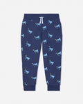 A pair of navy blue jogger pants featuring an all-over print of cartoon cows in light blue and yellow, with a white drawstring at the elastic waistband.