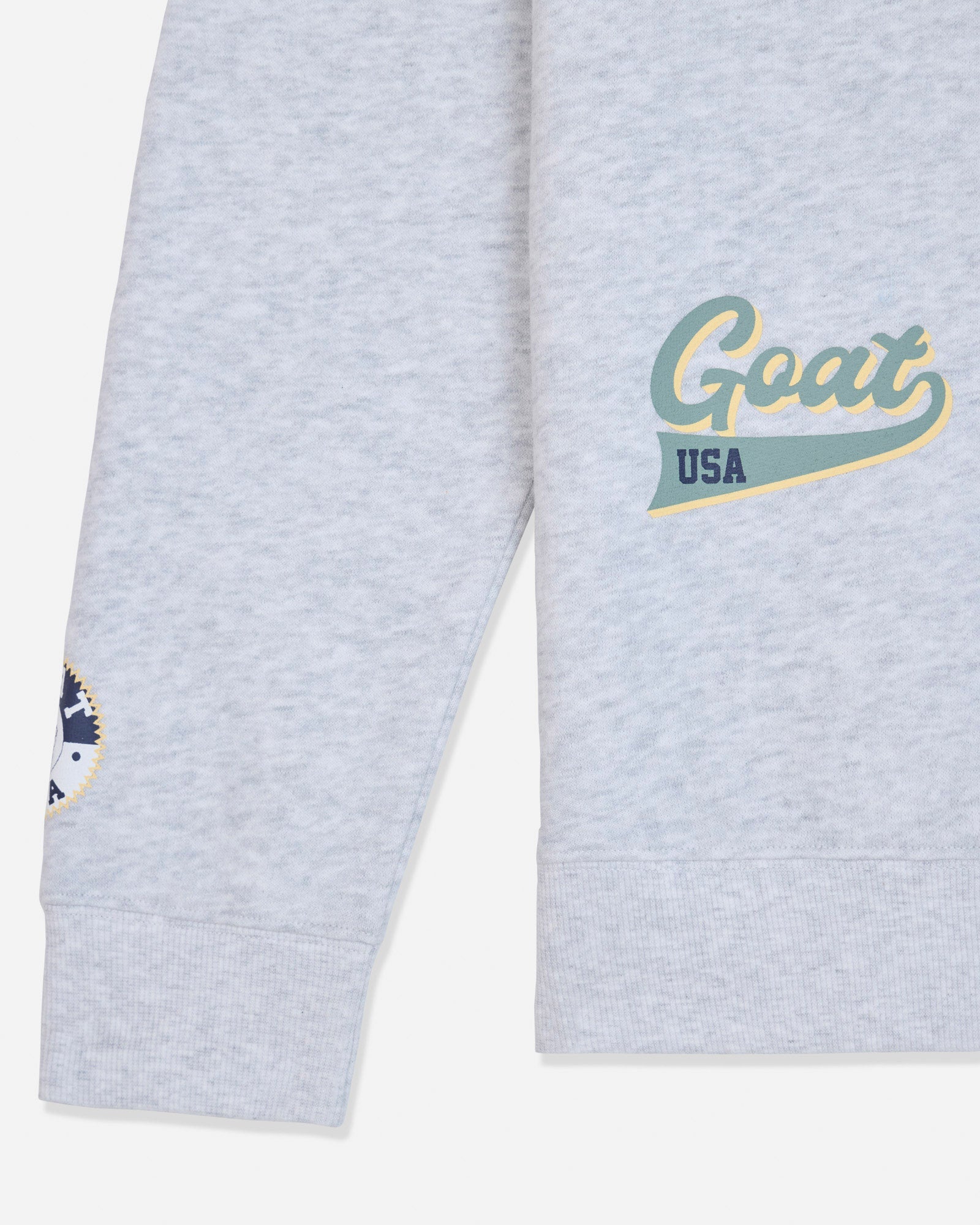 Sleeve of gray crewneck with patches