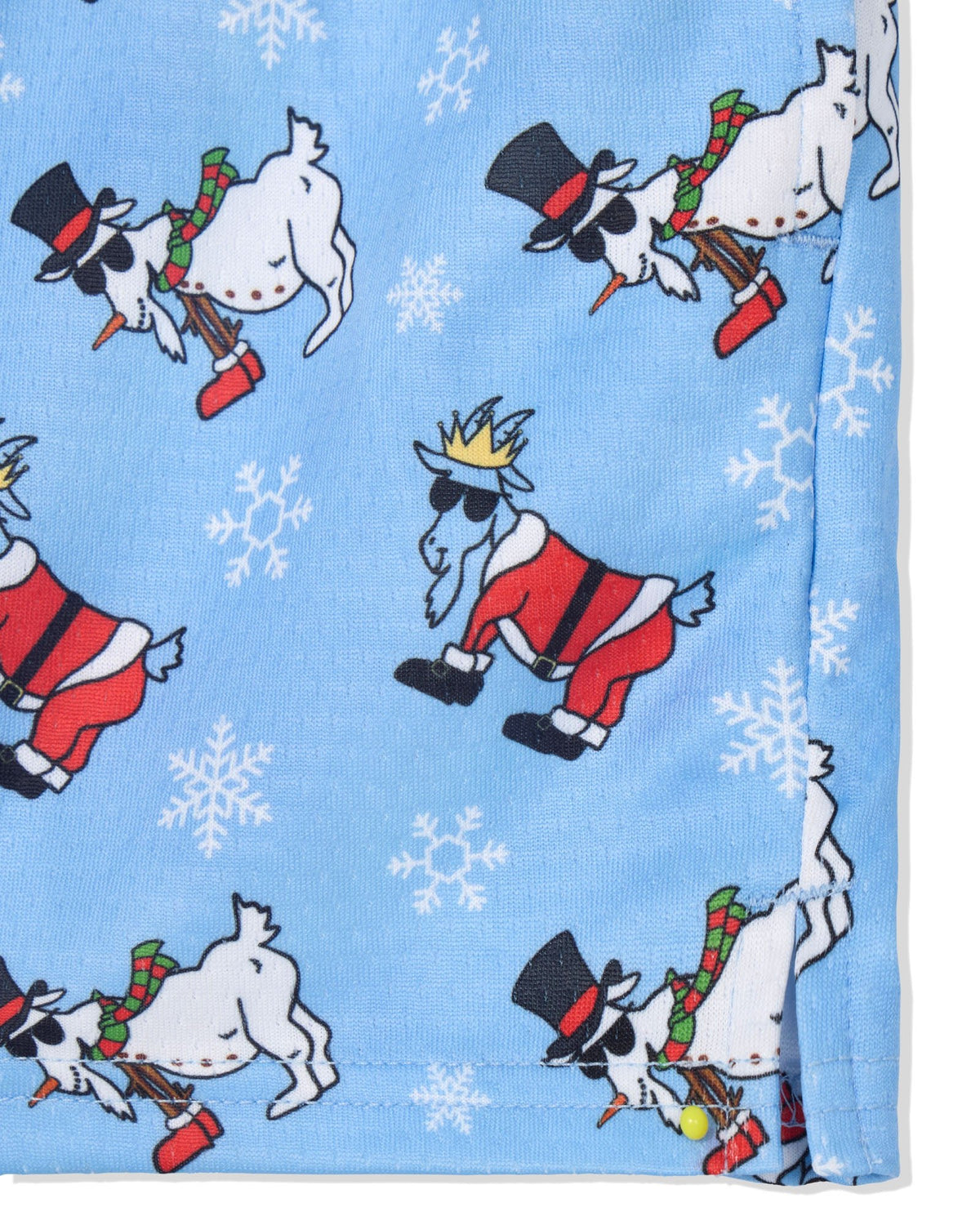 A close-up of a light blue fabric with a repeating pattern of cartoon goats dressed in Santa-style clothing, some wearing top hats and scarves, with white snowflake motifs.