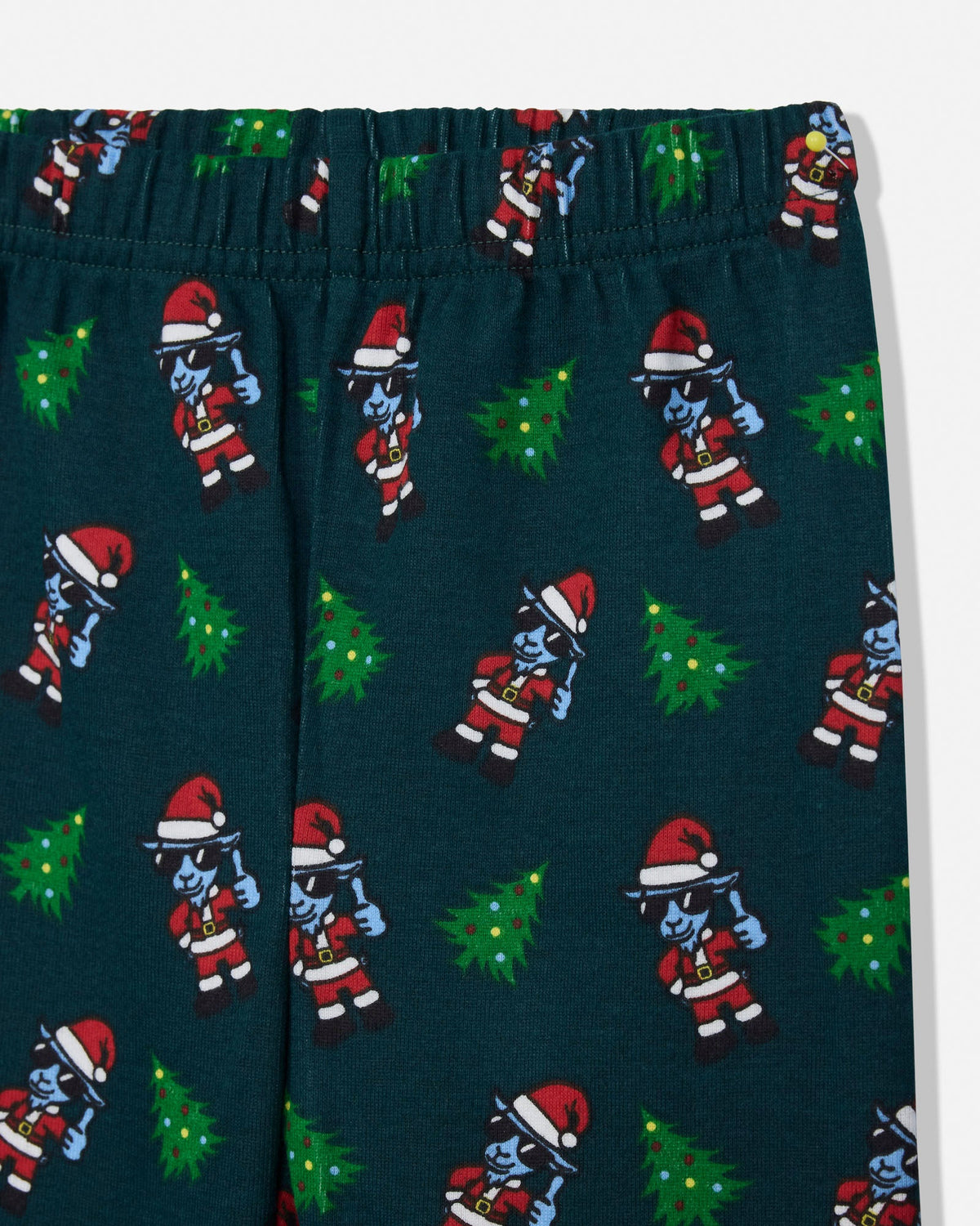 Dark teal holiday-themed lounge pants featuring a repeating pattern of blue-skinned Santa-clad figures and green Christmas trees, shown on a white background.
