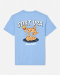 A light blue short-sleeve t-shirt shown from the back, featuring a cartoon graphic of a goat wearing a crown and standing on chocolate chip cookies, with the text 'GOAT USA' and 'Sweet Bites'.