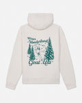 An off-white hooded sweatshirt shown from the back, featuring a dark teal graphic print of pine trees, mountains, and the text 'Winter Wonderland Goat Usa'.