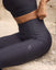 Person wearing black leggings with a brand logo on a textured surface