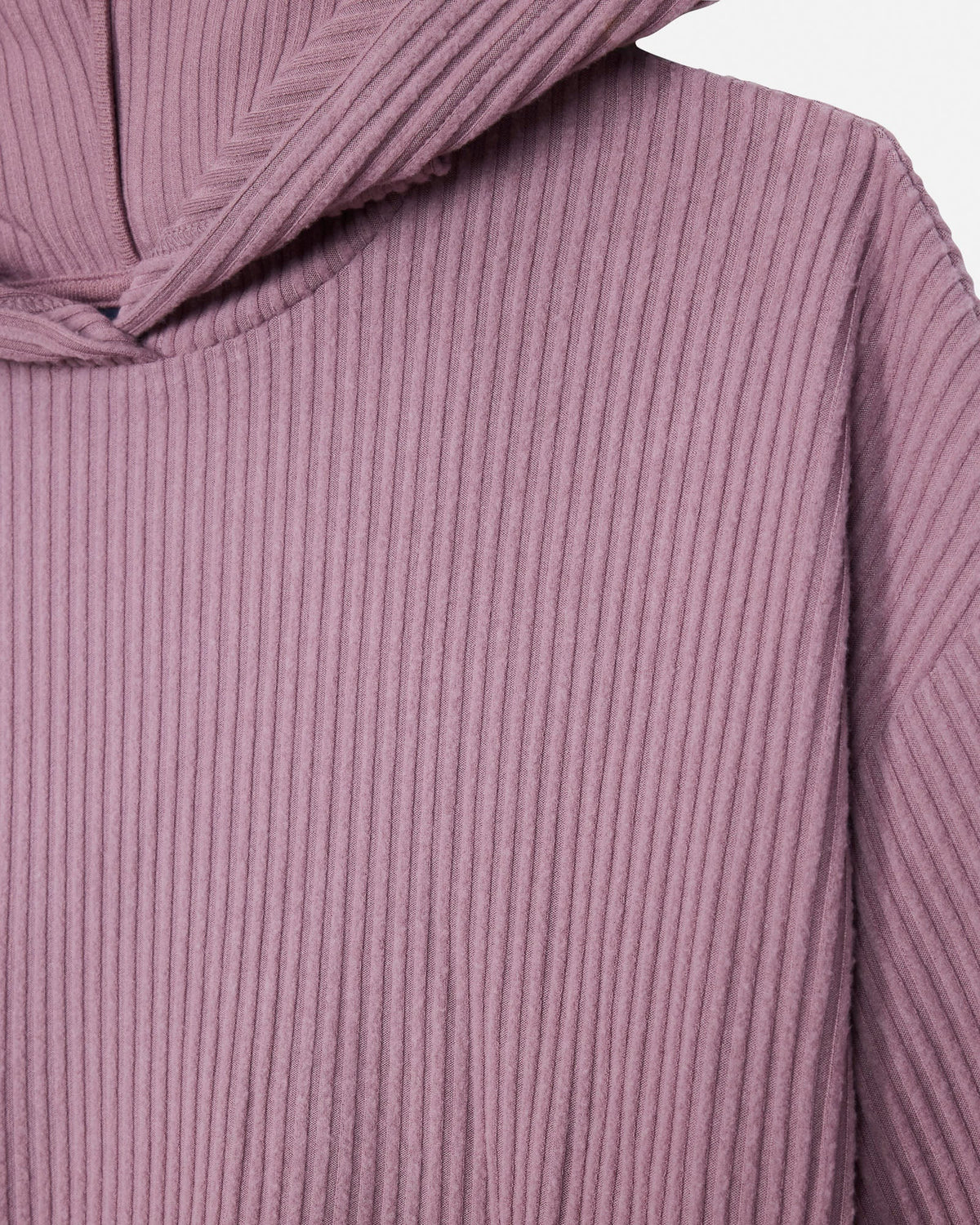 Close-up of a ribbed knit garment in a muted dusty mauve or mauve-rose color, showing the vertical corduroy-like texture and part of the neckline.