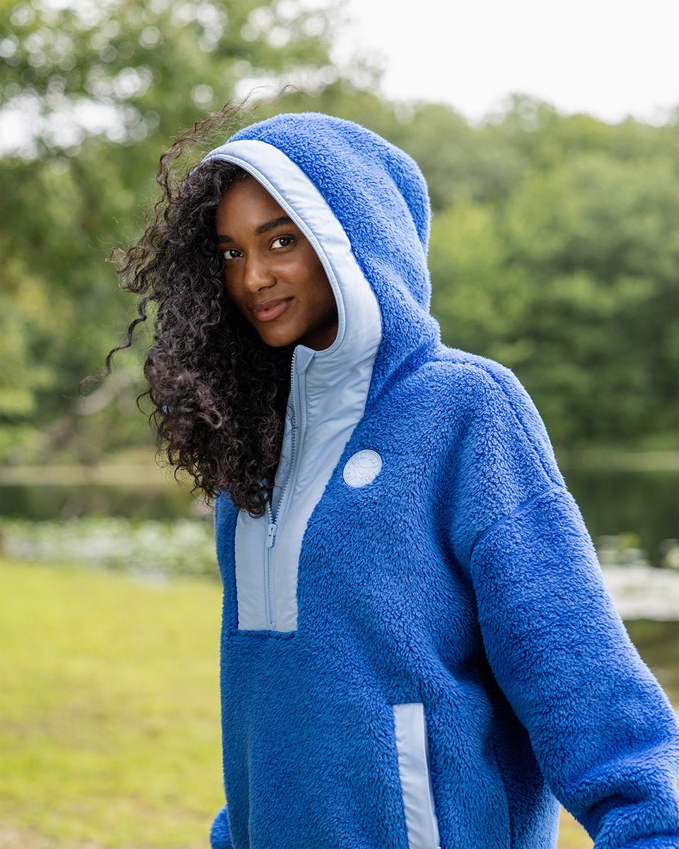 Person standing in a blue sherpa hoodie outdoors#color_royal