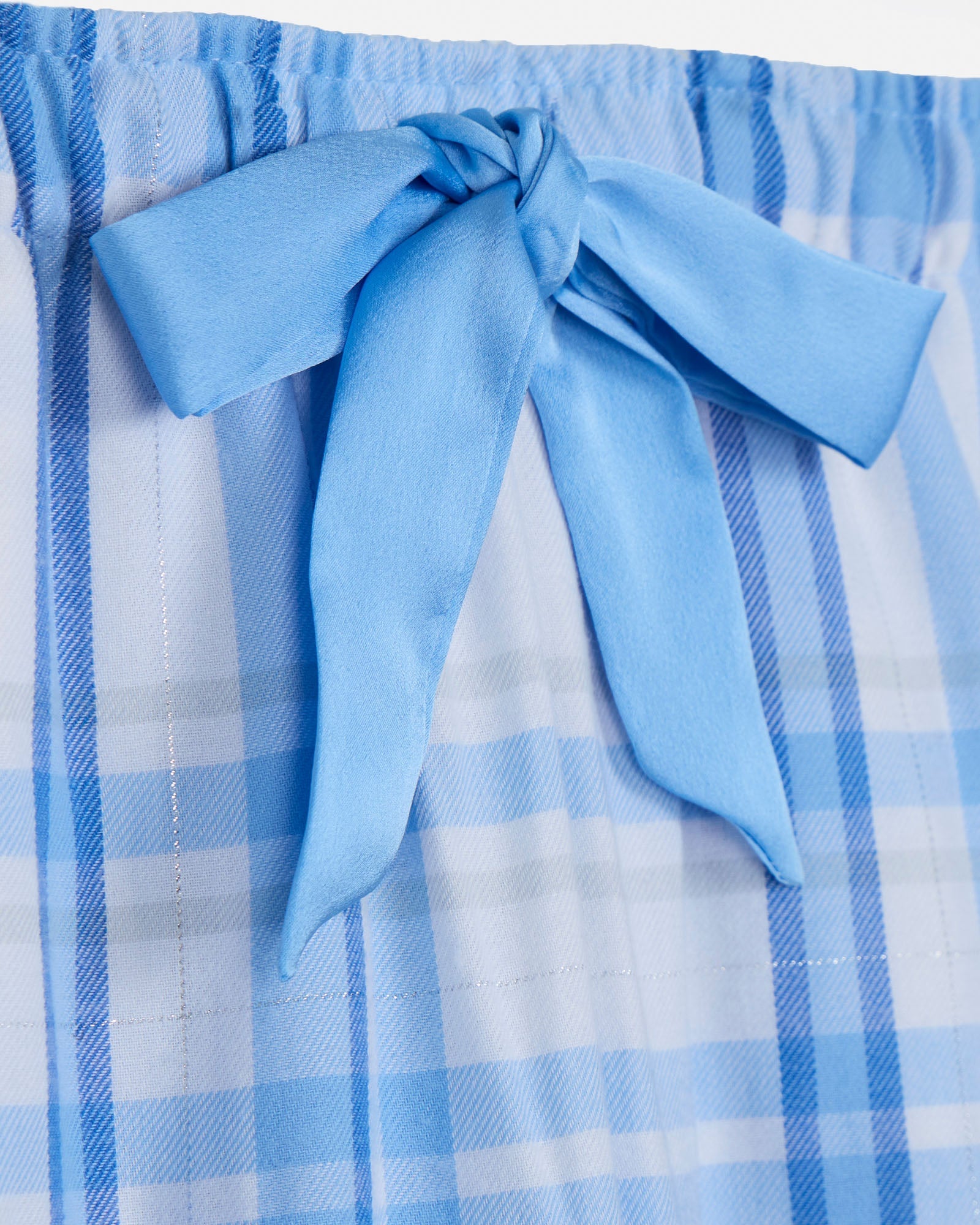 Blue plaid fabric with a large bow on a light gray background
