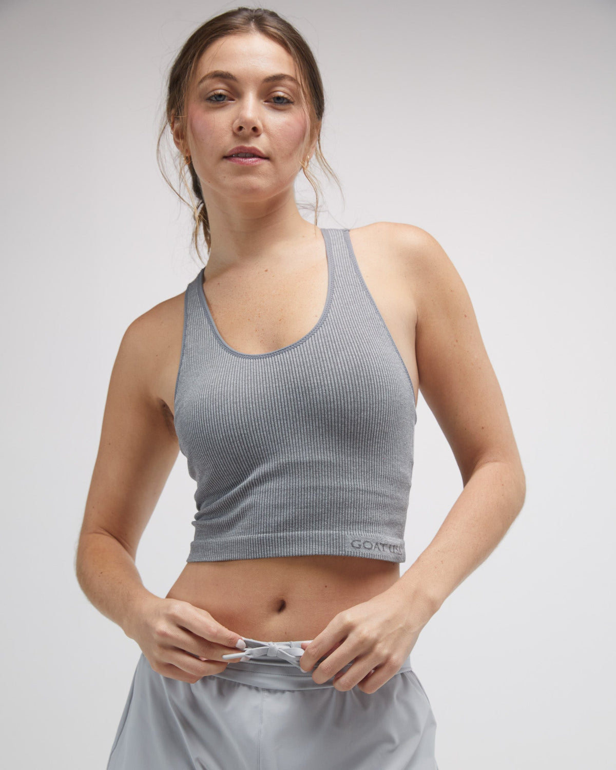 Front view of woman wearing gray seamless tank top