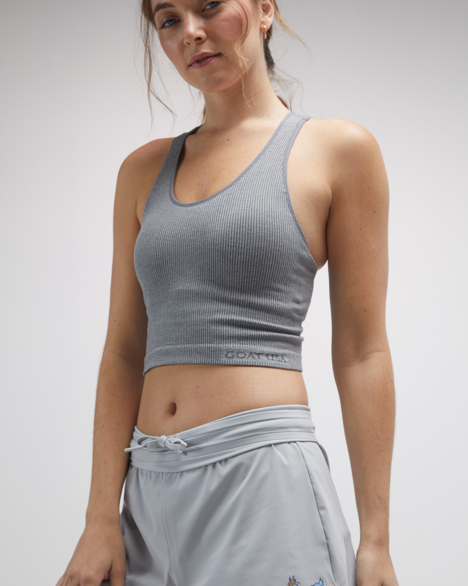 Side view of woman wearing gray seamless tank top#color_gray-heather