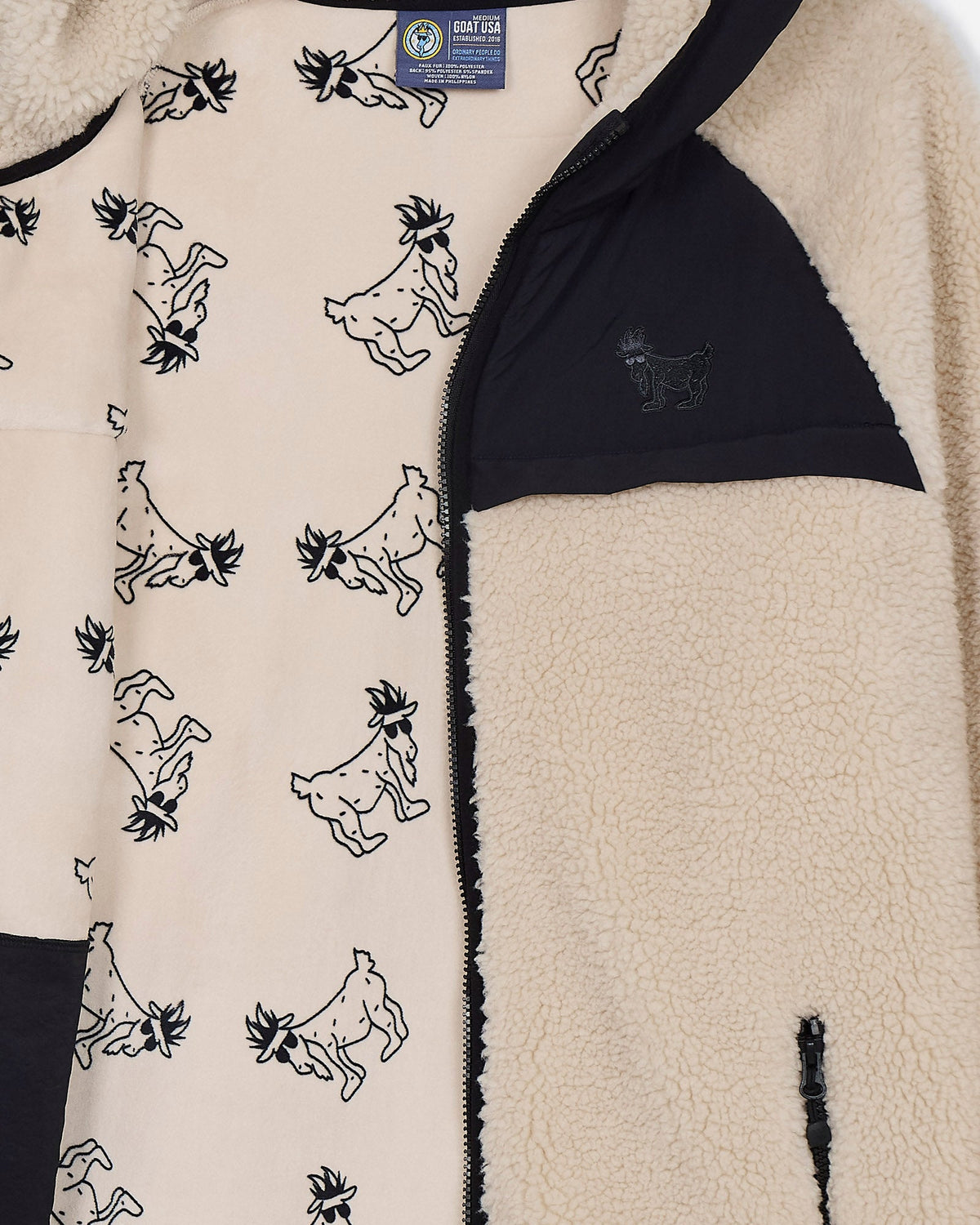 Close-up of a fleece jacket with goat pattern and visible brand label.